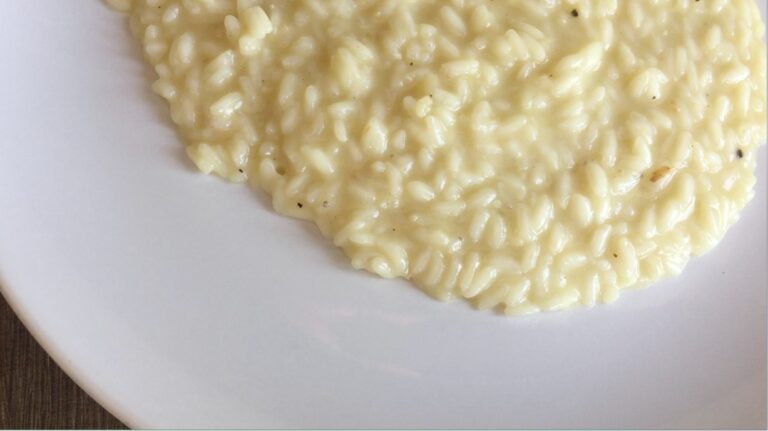 Creamy risotto served with Parmigiano-Reggiano, highlighting texture, aroma, and regional craftsmanship